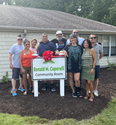 Group picture in front of the coummity room sign
