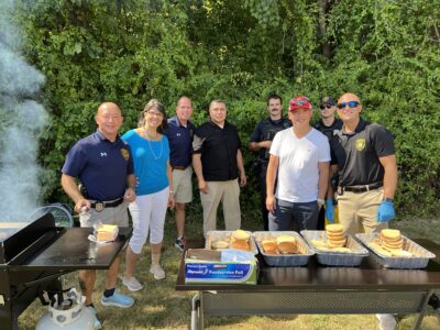 Board members with the police in front of the grill