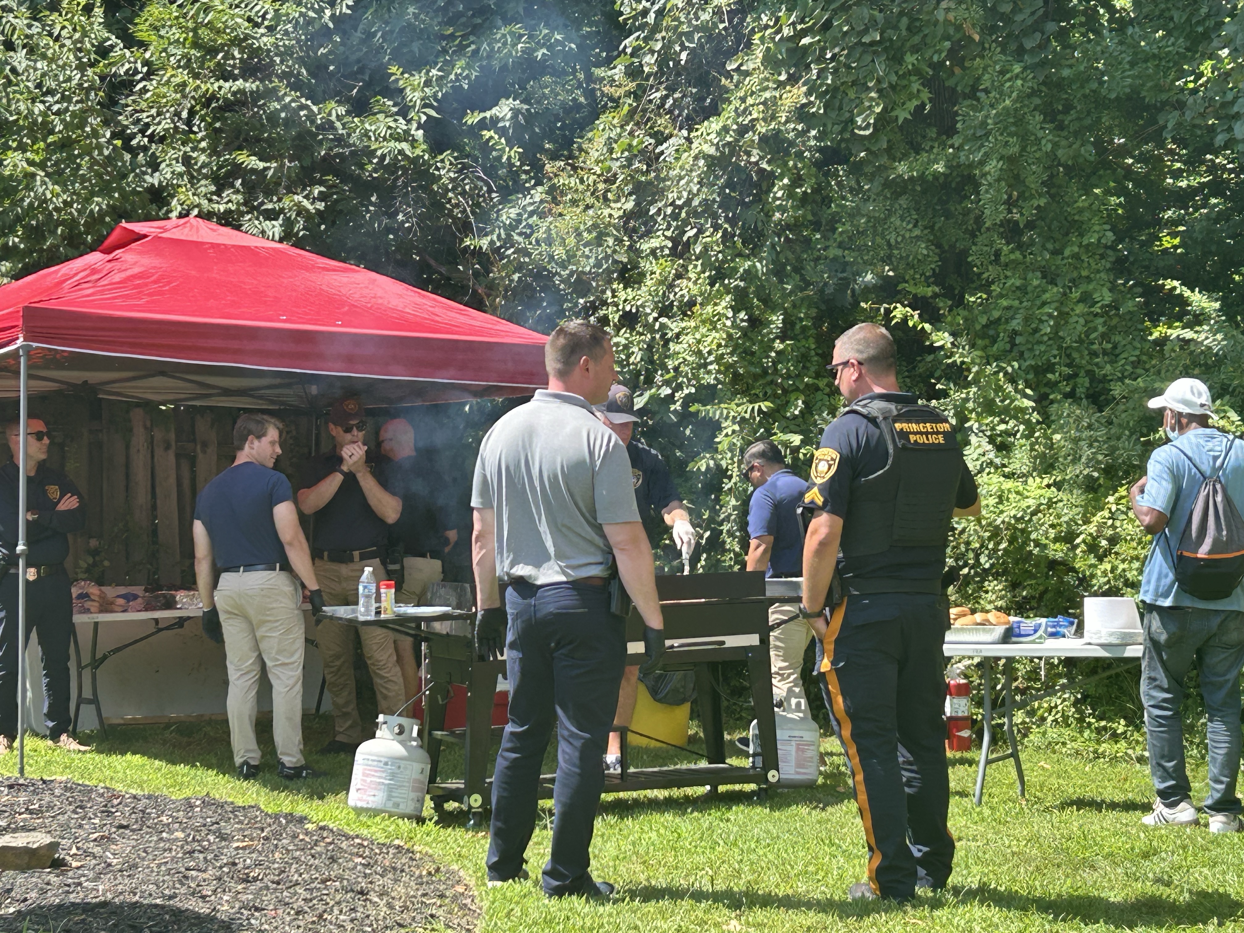 Image of residents and authorities grilling food
