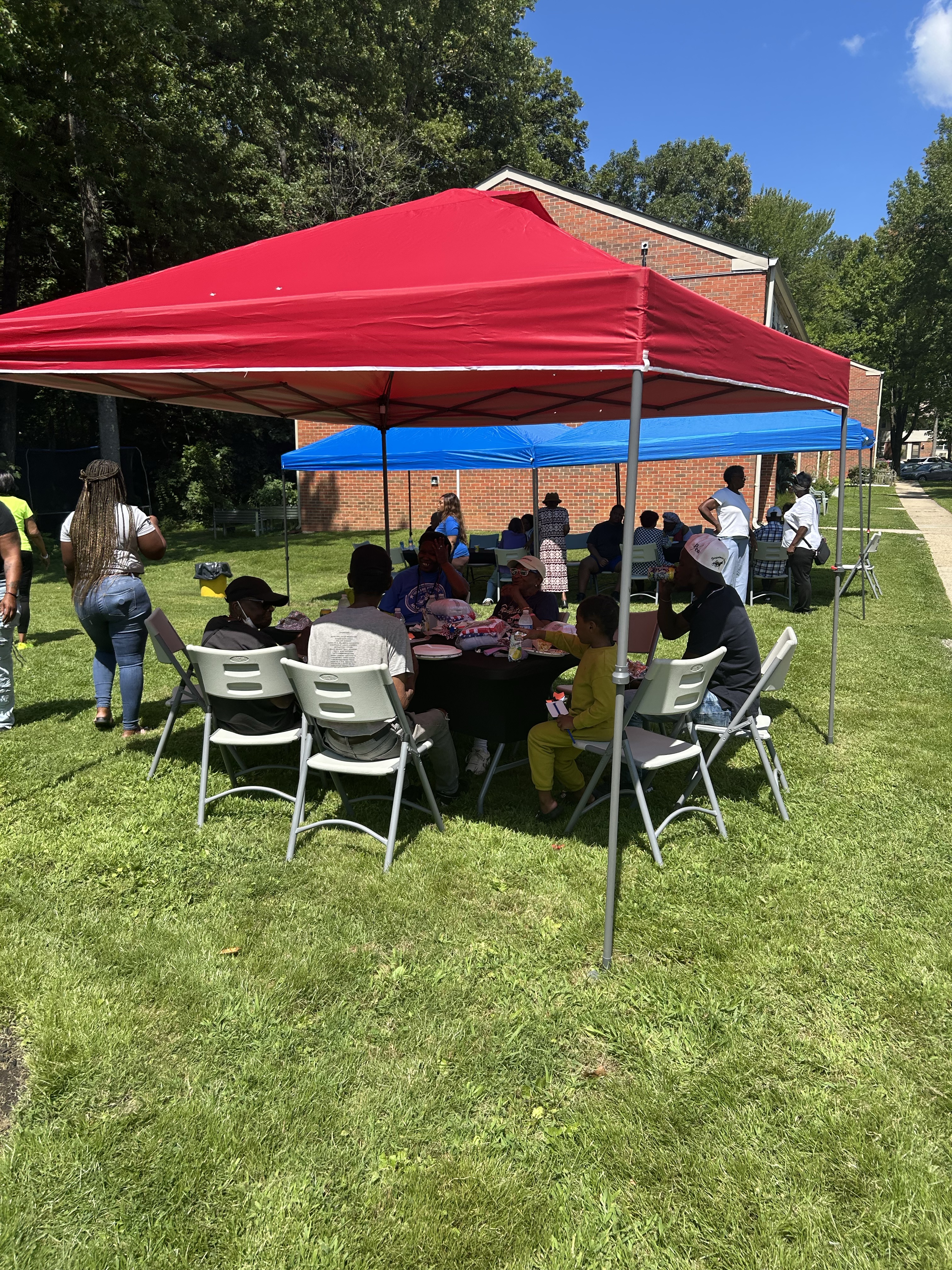 Tenants eating under a tent